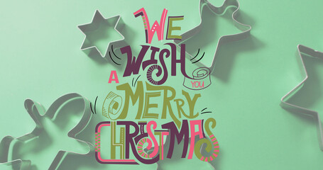 Image of merry christmas text over cookie cutters