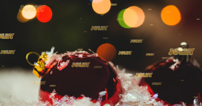 Image of jolly text in repetition over christmas baubles