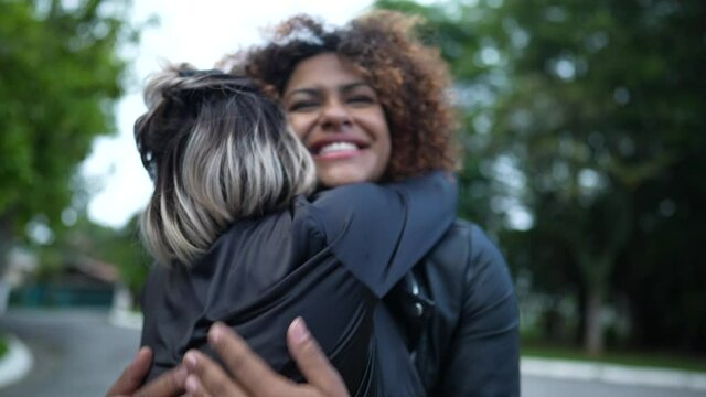 Two friends hugging each other outside, diversity friendship