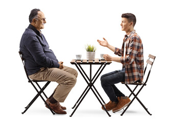 Obraz premium Young man talking to a mature man and sitting in a cafe