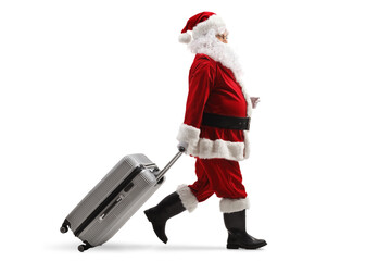 Full length profile shot of santa claus walking and pulling a suitcase