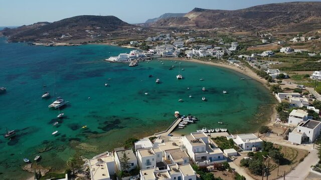 Aerial drone rotational video of picturesque fishing village of Polonia with traditional fishing boats anchored next to island of Kimolos, Milos island, Cyclades, Greece