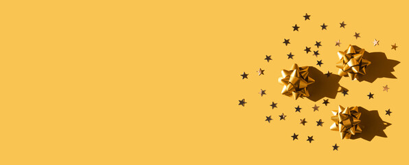 Gift golden bow with stars composition on monochrome yellow background. Winter, sale and seasonal concept. Merry Christmas, New Year, celebration banner. flat lay, top view, space or place for text