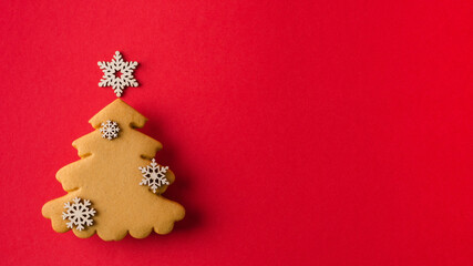 Christmas, New Year's background for the presentation of products. Natural and Gingerbread Christmas Tree with Wooden Snowflakes on Red Background