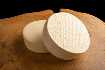 Semi-cured cheese from Brazil, beautiful Brazilian cheese arranged on light rustic wood, selective focus.