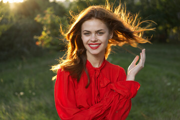 cheerful woman in a red dress in a field outdoors fresh air