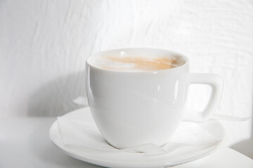 White Cup of Hot Coffee with Saucer, Cappuccino, Coffee Latte Americano on Light Background Close-up. Template for Menu of Drinks of Coffee Shops and Restaurants with Natural Shade, Copy space