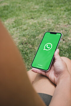 Female hand holding a smartphone with app WhatsApp on the screen. Park setting, sitting in the garden. Rio de Janeiro, RJ, Brazil. November 2021