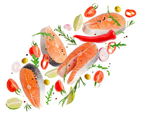 Raw steaks of salmon fish flying with spices and herbs isolated on white background.