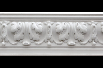 A fragment of a white plaster ceiling molding with an ornament.