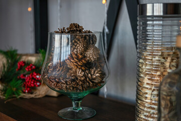 Large glass vase with pine cones. Natural Decorating for Christmas. New year holiday, celebration concept