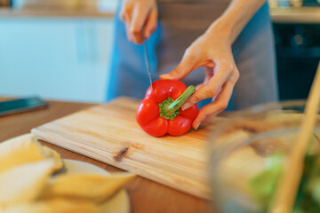 Woman preparing vegetables for organic salad in modern kitchen. Healthy eating and lifestyle concept