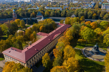 Fototapeta na wymiar Panoramic aerial view of the Kremlin in Veliky Novgorod, golden autumn in the city, yellow treetops, a bridge over the Volkhov river, city sandy beach, a fortress.Millennium of Russia.