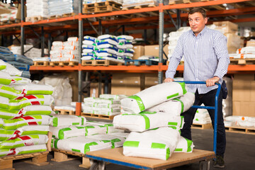 Serious man buying compost soil for gardening in hypermarket