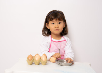 Beautiful little asian girl cooking isolate on white background