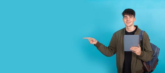 student with tablet isolated pointing the background with space