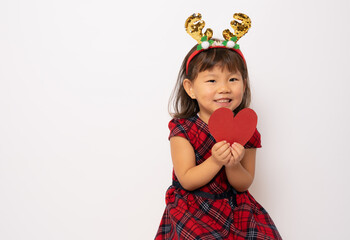 Beautiful little asian girl in santa hat showing a red heart isolated over white background.