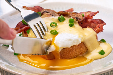 Poached egg Benedict with hollandaise sauce on toasted brioche