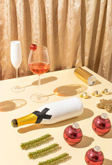 Christmas party scene with rose vine glass, champagne, fir branches and red baubles against golden silk curtains. Creative luxury New year party.