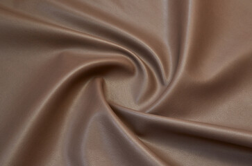 brown artificial leather with waves and folds on PVC base