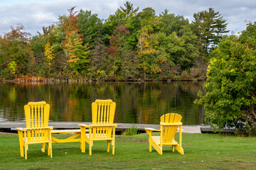 muskoka chairs on lake in autumn