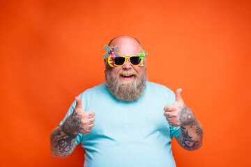Fat happy man with beard, tattoos and sunglasses is ready for the summer
