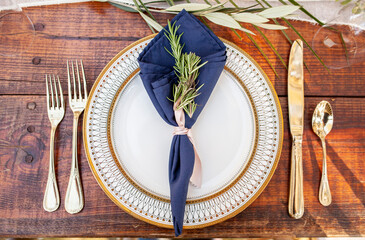 Beautiful plate and silverware with decoration on wooden table for outdoor dinner or wedding...