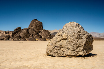 Low Angle of Sailing Stone On The Racetrack Playa With The Grandstand In The Background in Death Valley