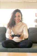 Obraz premium Laitin woman playing videogames with hands holding joystick