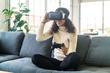 Latin woman using a virtual reality headset on sofa © topntp