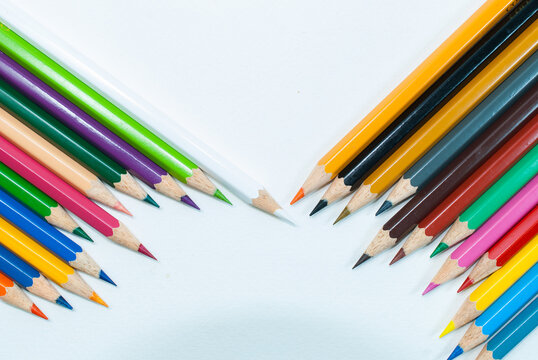 Top view photo of various colored pencils. placed on a white background and bright colored pencils placed diagonally alternating colors in close-up, top view, concept art, text and office copy space