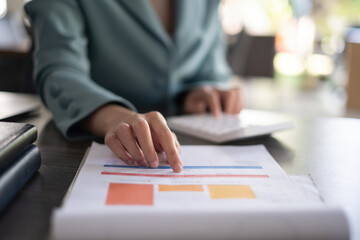 A businesswoman's hand points to the company's budget chart for audit account