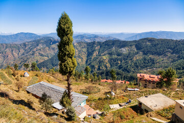 Scenic hill station aerial view with village houses on the mountain slopes with Himalaya landscape...