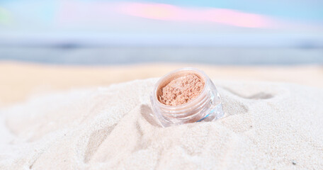 Fototapeta na wymiar mineral cosmetic, eyeshadows or pigment in a container on sandy beach. summer shining cosmetic, light and glitter