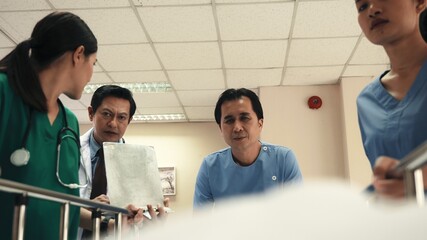 Emergency Department. Nurse and senior doctor team busy push emergency stretcher transport senior patient in hospital, doctors, nurses in surgical gown and white coat uniform running with hurry