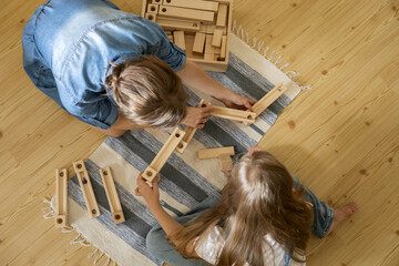 Mother and kid daughter playing wooden track ball constructor block toy Maria Montessori materials