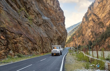 Truck driving along national highway road with scenic mountain landscape at Himachal Pradesh, India