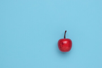 Obraz premium Red apple in syrup on a blue background. Minimalism. The concept of a winter sweet apple dish.
