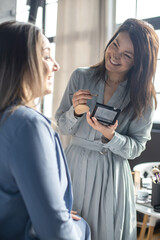 Professional female makeup artist applying cosmetics on model face use brush working at beauty salon
