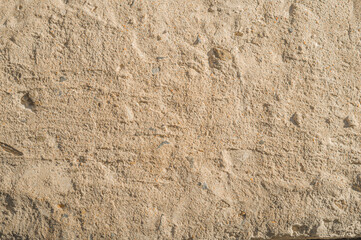 Old concrete pavement with potholes. Beige tone of the coating. Abstract background