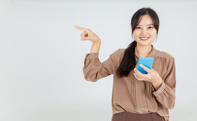Gorgeous young Asian woman cheerfully pointing finger with smile to interesting copy space for...