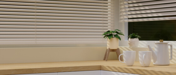 Modern light wooden kitchen countertop with a white ceramic tea sets and space for montage