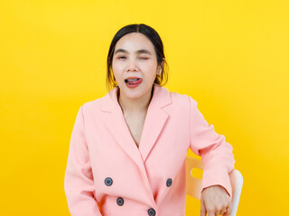 Naughty and sexy Asian girl on beautiful pink jacket twist tongue, close eye and pose kidding face...