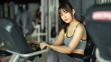 Fototapeta na wymiar Beautiful sporty girl in sport wear exercise on fitness bicycle