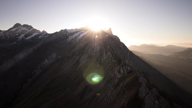 Day to night sunset timelapse at Schafler ridge in Appenzell, Switzerland with the golden glow behind the cliffs of Alpstein slowly turning into blue sky full of stars