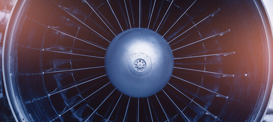 Closeup detail of turbine airplane engine blades. Blue color tone with sunlight
