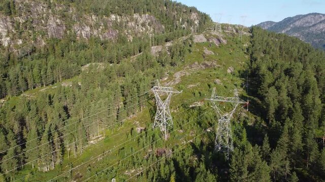 High voltage power cables and mast - Distribution of electricity from hydroelectric powerplants in Norway - Sunny day aerial from Hallingdal highlands
