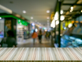 Wooden table in front of blurred background and round bokeh, storefront in a shopping mall.