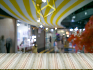 Blurred background and round bokeh, white and yellow, shopping mall corridor, with artificial wood table in front.