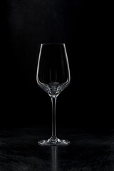 Empty wine glass. Black background, backlight.